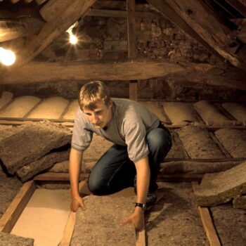 Man fits insulation in Penrith, UK, Image via Ashden / Ashden