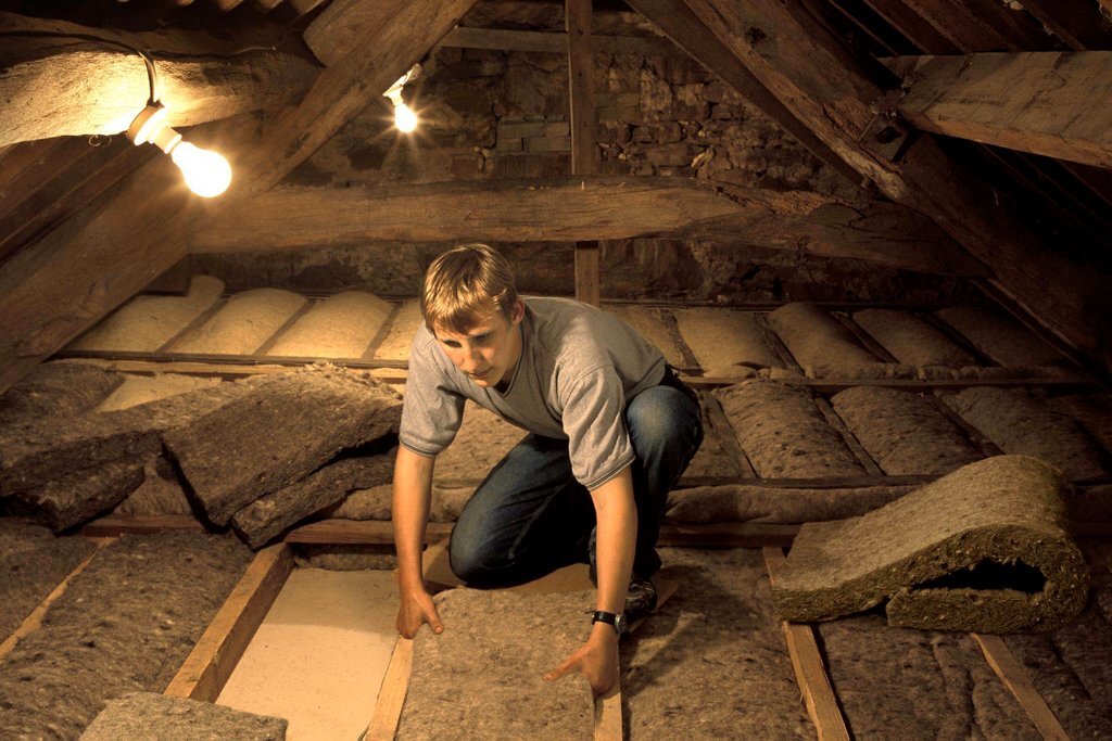 Man fits insulation in Penrith, UK, Image via Ashden / Ashden