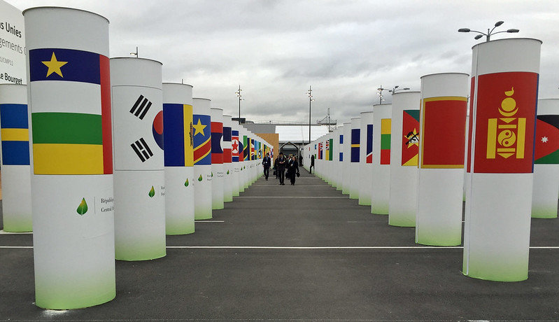 Columns with flags for each country outside the COP21 climate conference in Paris. Image via Flickr: becker271