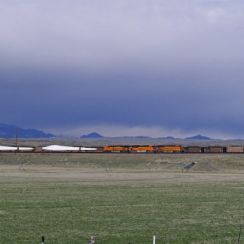 A train carrying wind turbine blades passes a coal train idled on a siding, Orin Junction, Wyoming. Image via Flickr: wildearth_guardian