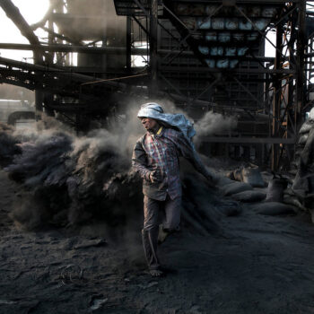 A man walks through coal dust at a coal mine, in Jharkhand, India. image via Rajesh Kumar Singh / Climate Visuals Countdown