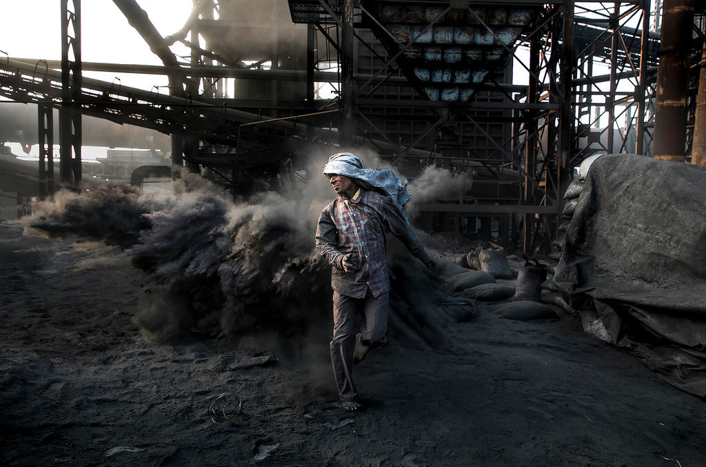 A man walks through coal dust at a coal mine, in Jharkhand, India. image via Rajesh Kumar Singh / Climate Visuals Countdown