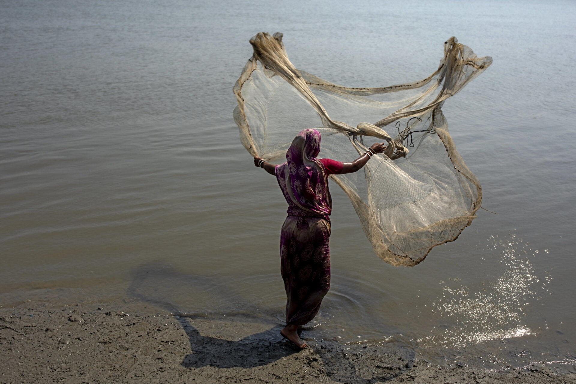 Woman catching fish, Bangladesh
