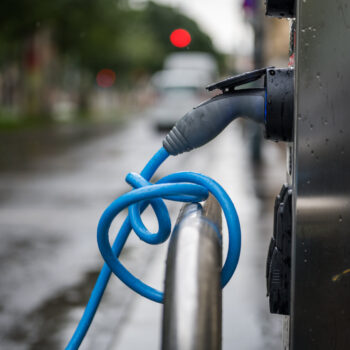 Electric vehicle charger plugged in and wrapped around the rail
