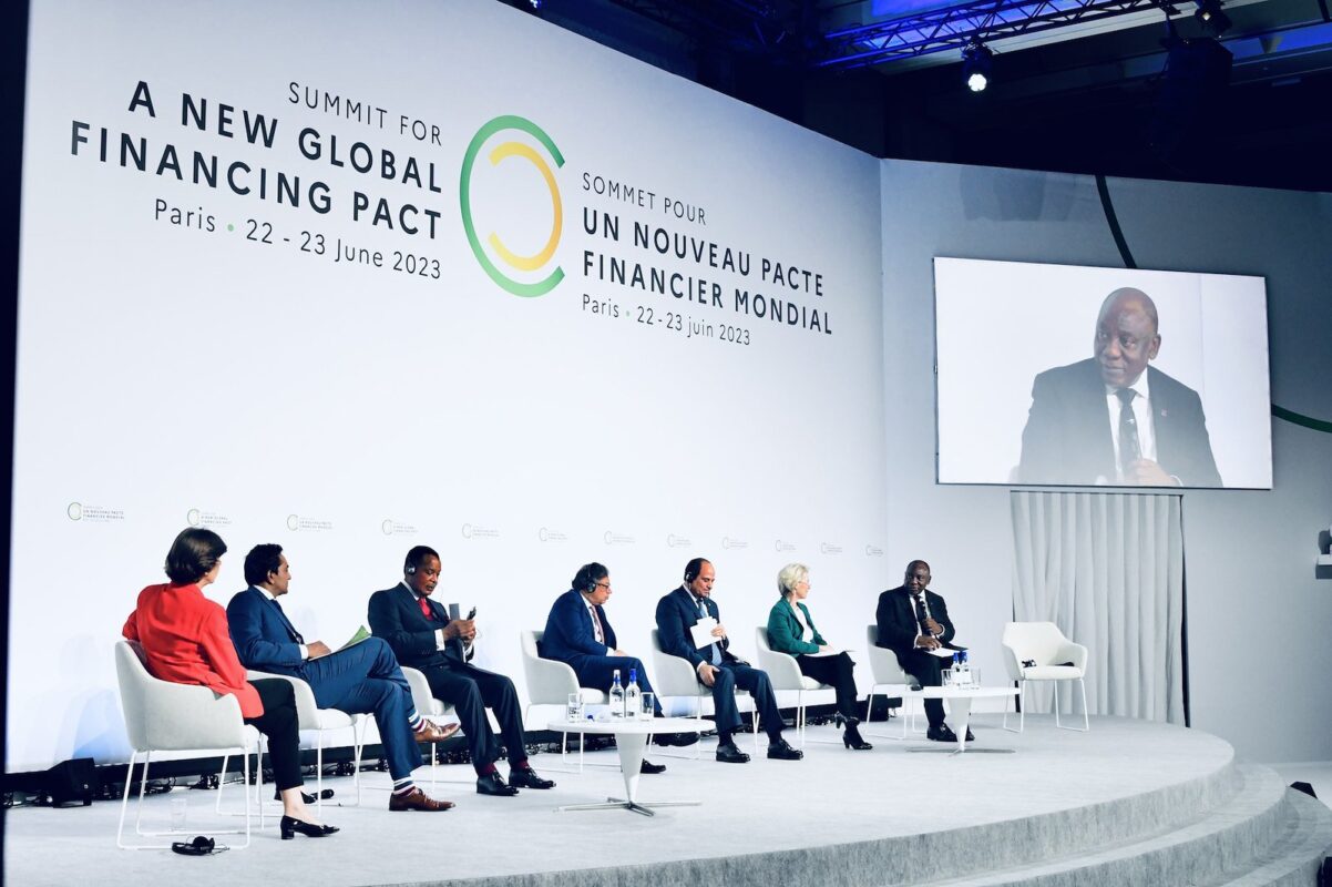 The image shows a high-level round table discussion themed “new methods: green growth partnership” of the New Global Financing Pact two-day Summit.