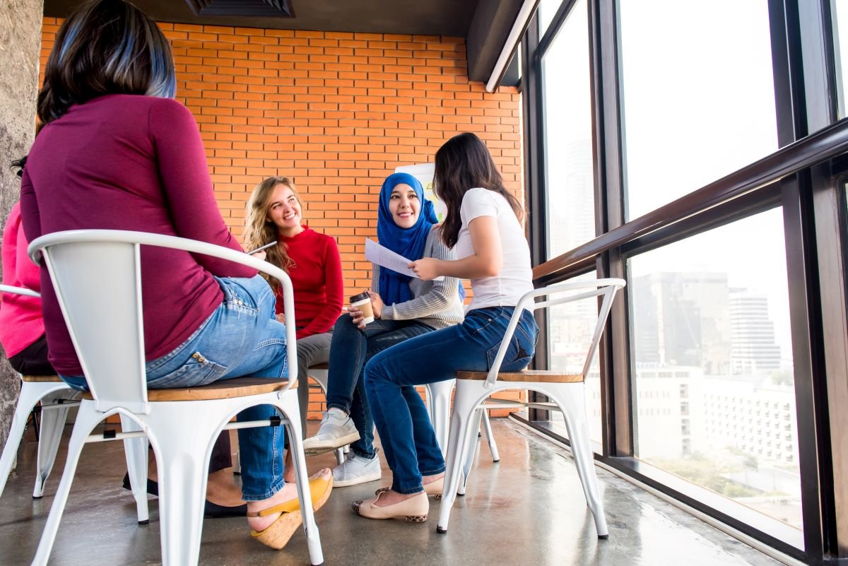 A group of women discussing shared ownership and community projects in a circle.