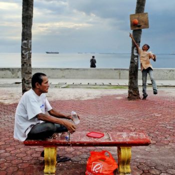 A man cools off with a drink and sea breeze in Baywalk, Manila Bay, Philippines. Image: Dominic Meily, CC BY-NC 2.0