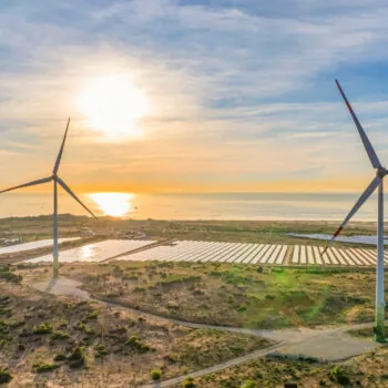 Tall windmill turbines against a clear blue sky, generating renewable energy in the serene Ninh Thuan, Vietnam landscape by the sea. Same with windmill park in the Noordoostpolder Netherlands