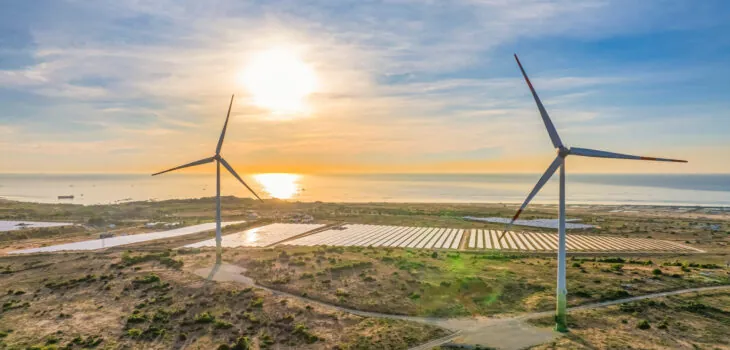 Tall windmill turbines against a clear blue sky, generating renewable energy in the serene Ninh Thuan, Vietnam landscape by the sea. Same with windmill park in the Noordoostpolder Netherlands