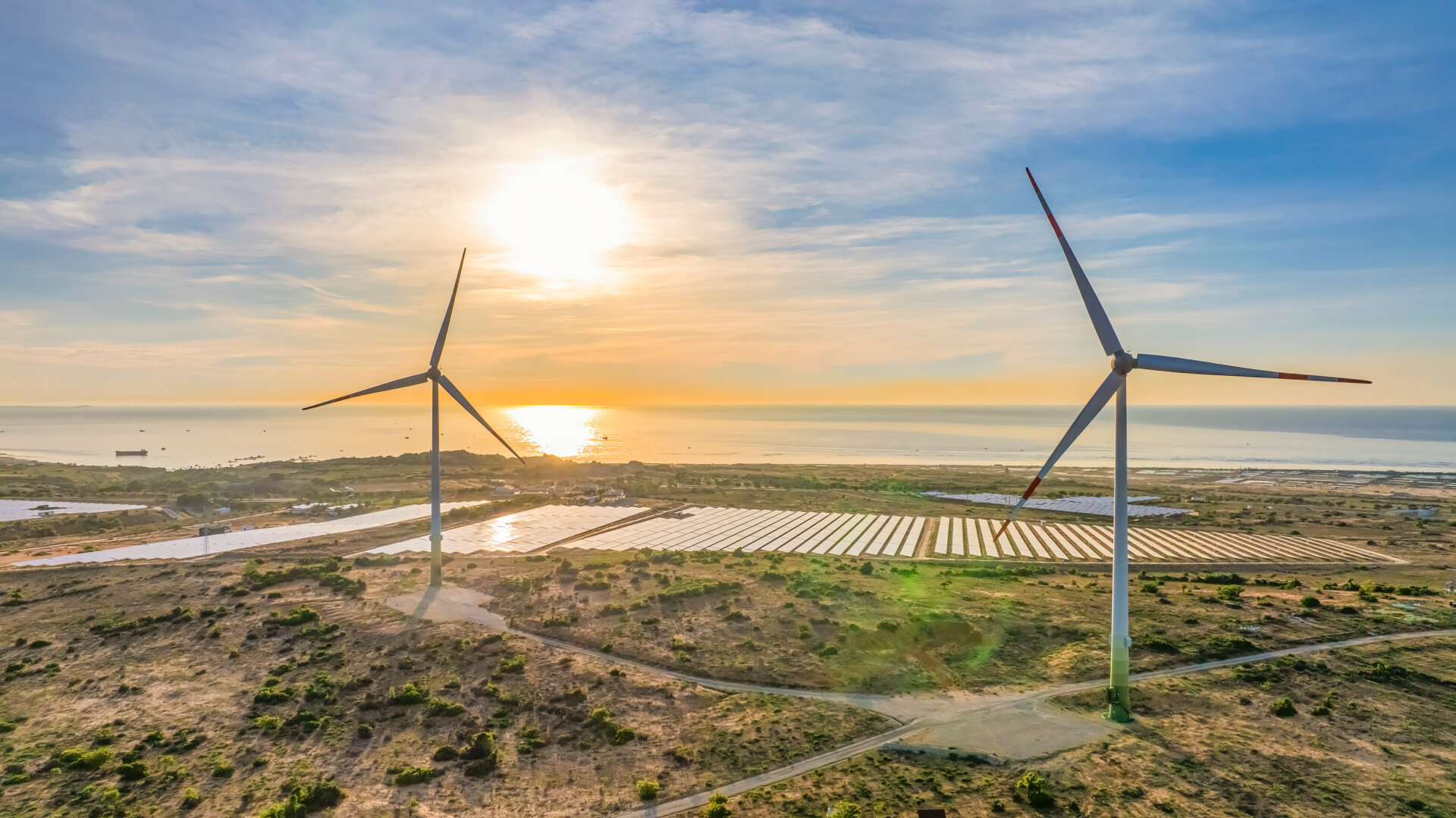 Tall windmill turbines against a clear blue sky, generating renewable energy in the serene Ninh Thuan, Vietnam landscape by the sea. Same with windmill park in the Noordoostpolder Netherlands