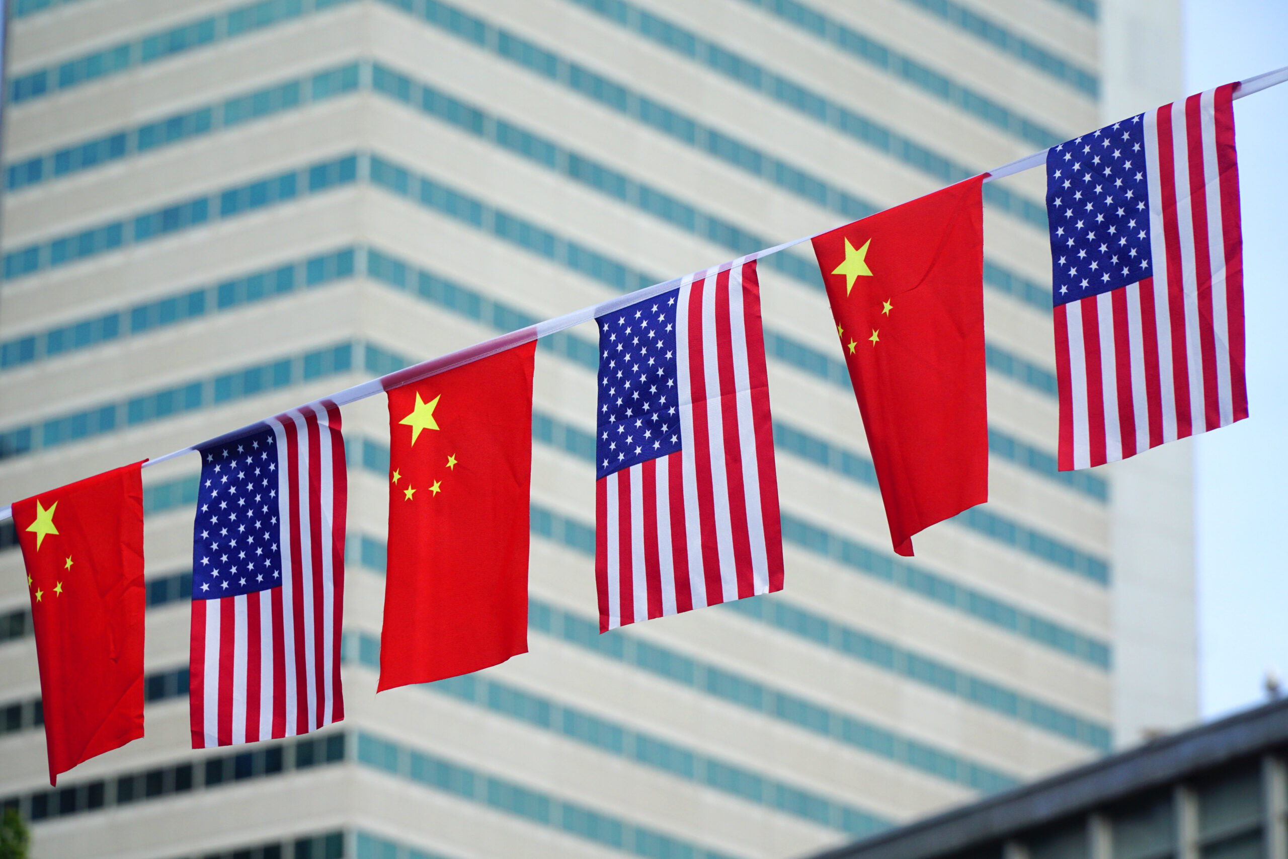 USA and China flags hanging in front of business building