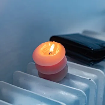 A burning candle, a radiator, and a wallet.