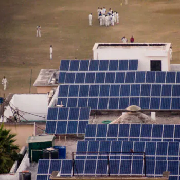 Children in white uniform playing on a cricket field powered by