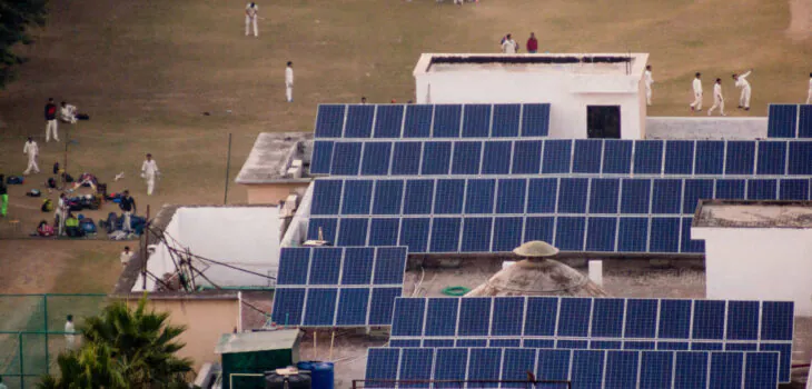 Children in white uniform playing on a cricket field powered by