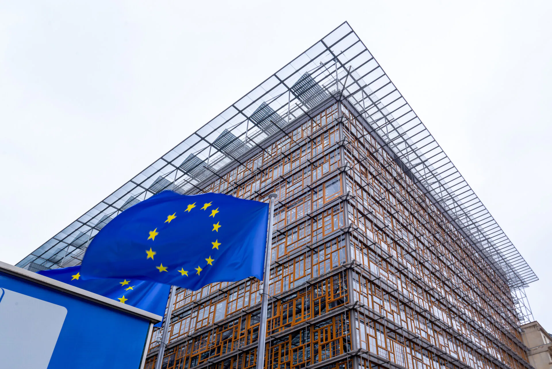 EU flag and the Europa building, headquarter of European Council and Council of the European Union in the European quarter in Brussels, Belgium