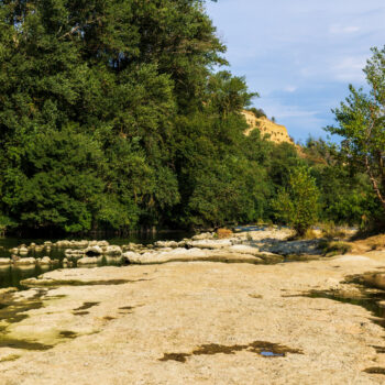 Partially dried-up course of the Ariège river in summer 2026, marked by severe heat waves and significant drought, seen from the Ramier de la Riverotte at Clermont-le-Fort
