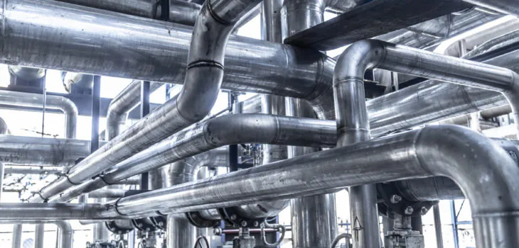 An image of industrial steam pipe with valves and stainless steel actuators