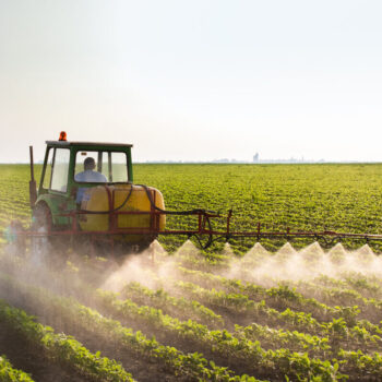 Tractor spraying soybean field