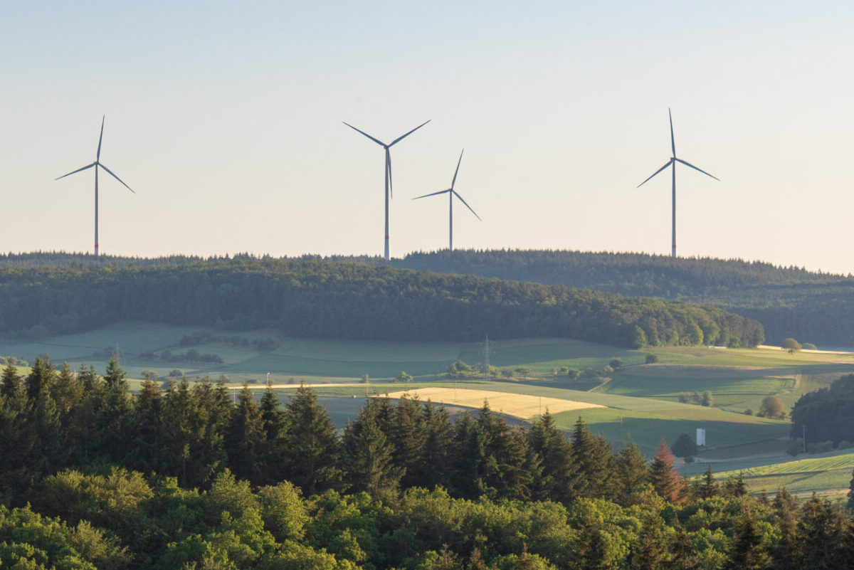 Wind turbines at the horizon in green rural landscape in Werbach