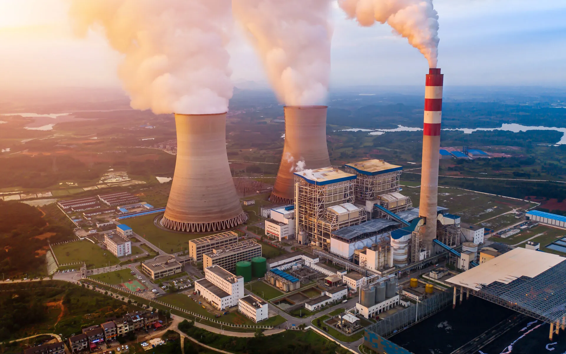 coal fired power station with cooling towers releasing steam into atmosphere