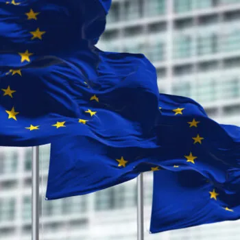 group of flags of the European Union waving in the wind