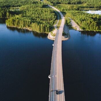 Aerial view of bridge across blue lake in summer landscape in Finland.