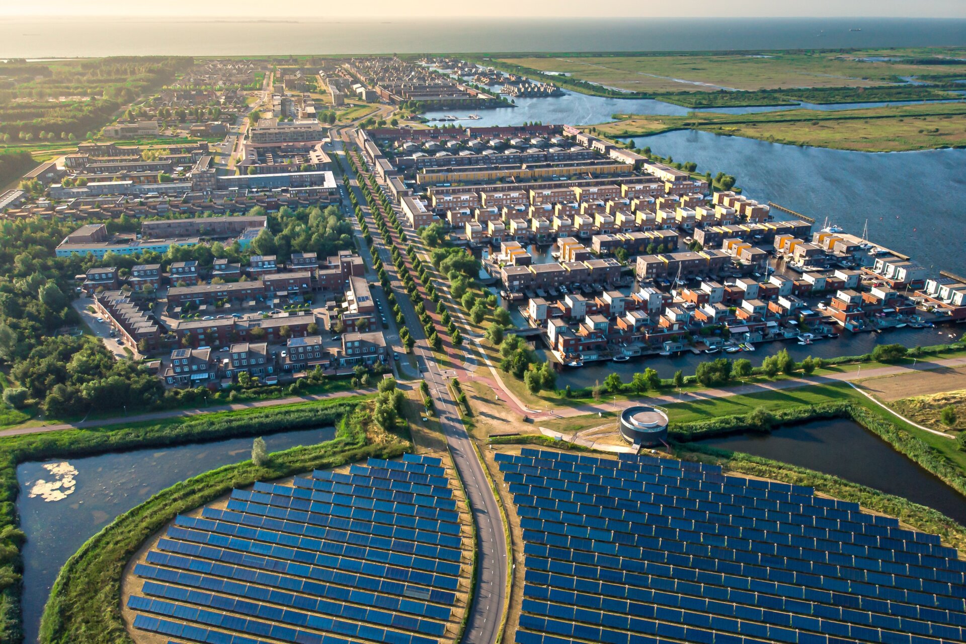 An arial shot of solar panels next to a residential community.