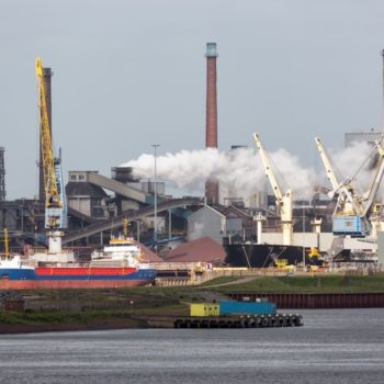 Big steel factory in harbor IJmuiden with cargo carrier in front, The Netherlands