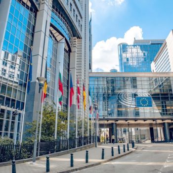Brussels, Belgium July 20, 2020. European Parliament offices and European flags. Photo via Adobe.