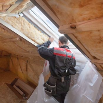 Builder installing barrier around the skylight opening in attic of home. Photo by Brizmaker on Adobe Stock