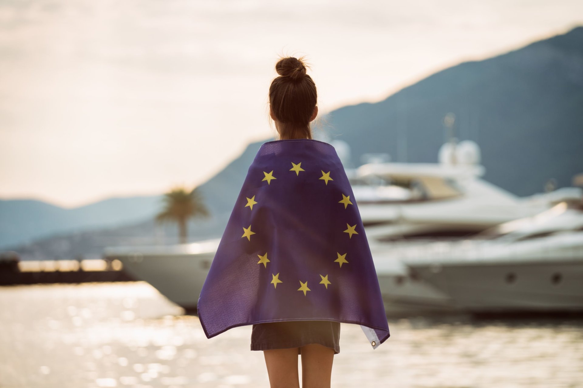 Child at dawn background of the sea European Union flag