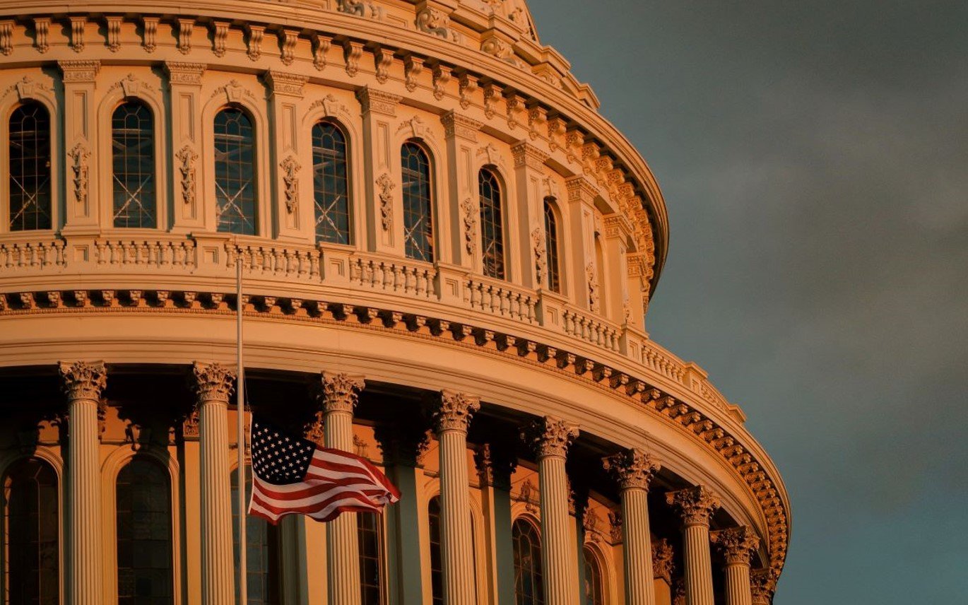 Close up of capitol building at dawn with US flag