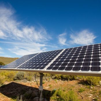 Close up wide angle view of photovoltaic solar panels on an off the grid electricity instalation on a farm in the Karoo outside Touwsrivier in the western cape of south africa