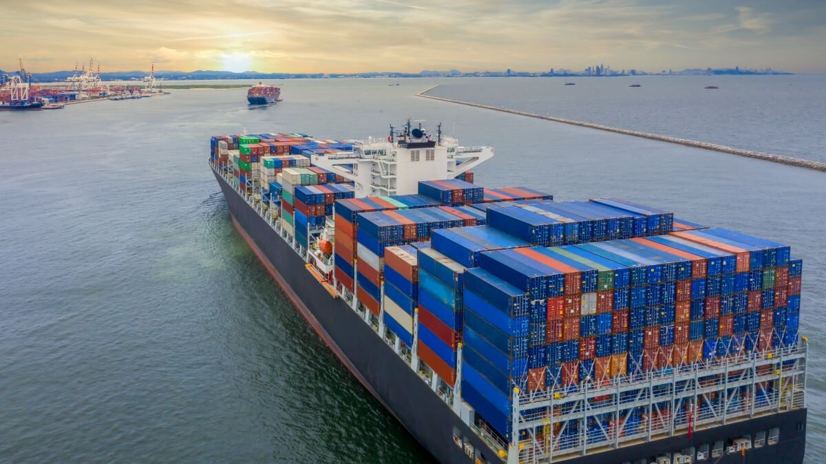Container cargo ship sailing over international waters. Photo via Adobe
