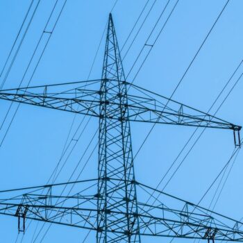 Electricity grid against a blue sky.