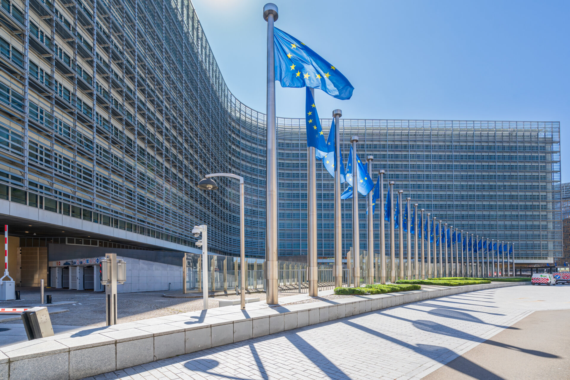 EU flags flying outside a large building.