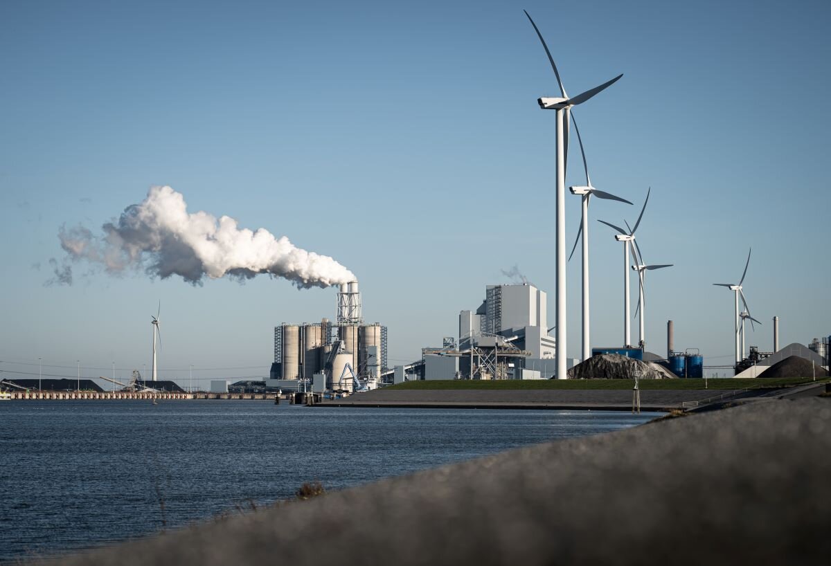 Fossil fuel - coal - power station and wind turbines in the Eemshaven generating power. Photo via Adobe.