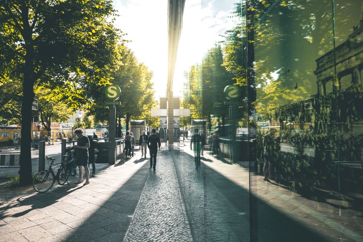 Green urban scene in Berlin with trees, glass building and cyclist. Photo by Tim David via Adobe Stock