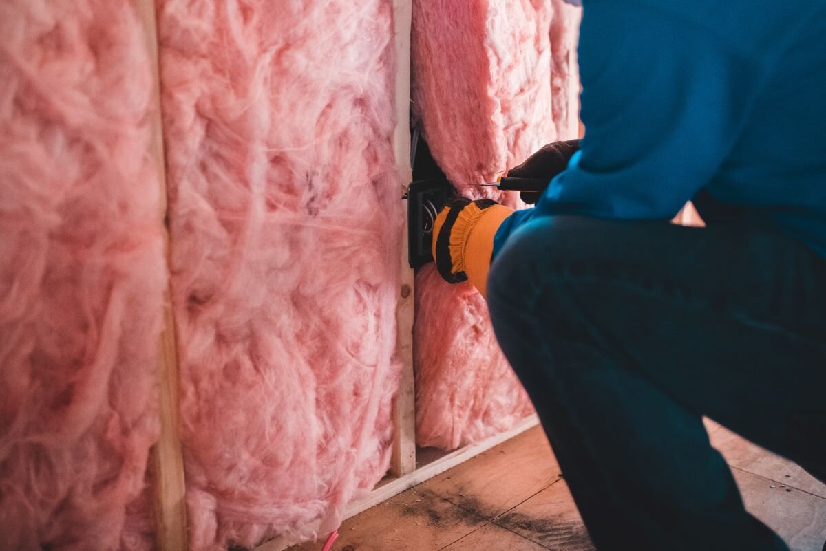 Installing insulation material in a home wall as part of energy efficiency measures to reduce the need for gas. Photo by Erik McLean on Unsplash.