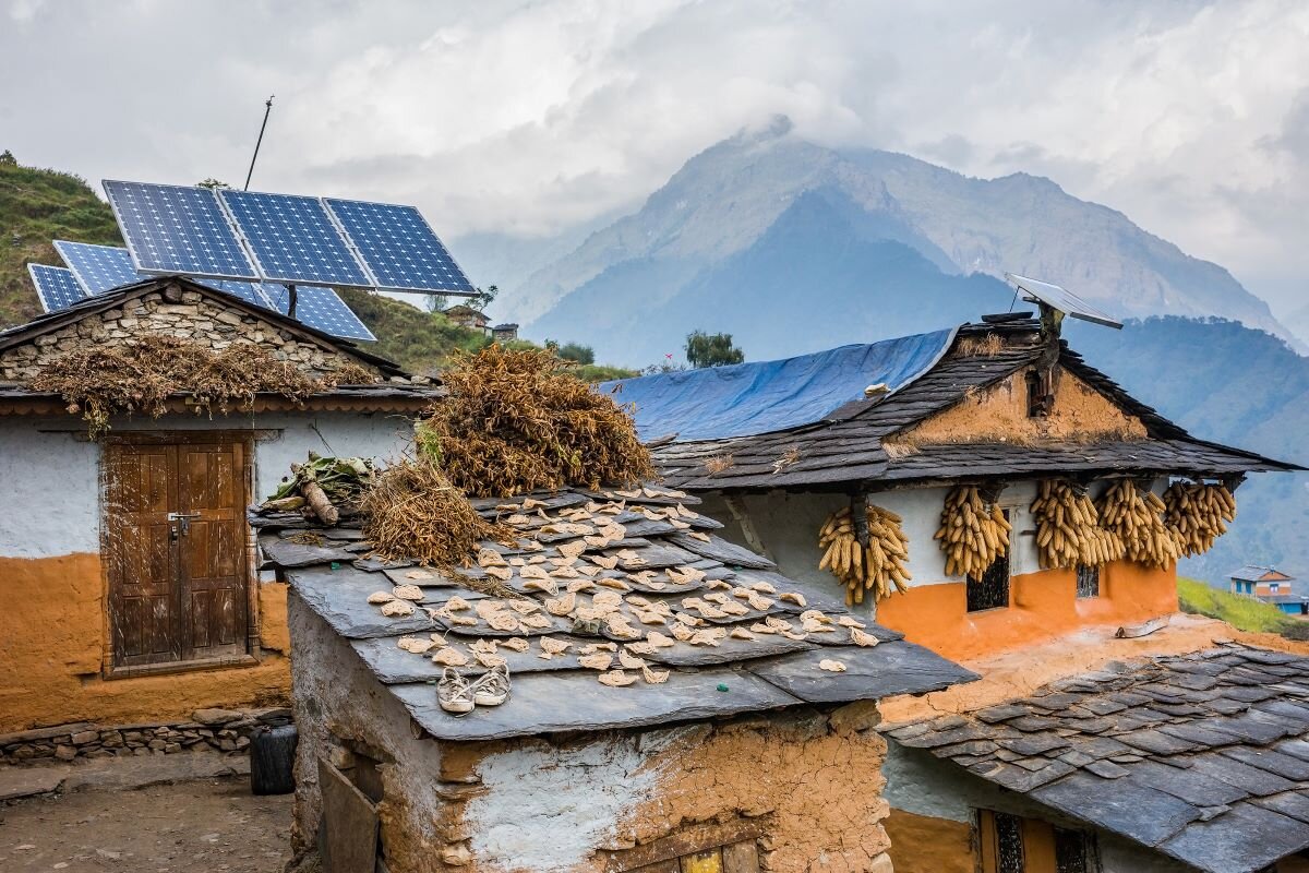 Nepali traditional houses with solar cell panel on the roof. Muri village, Dhaulagiri region. distributed renewables and small-scale storage, are well suited to expand energy access and deliver a quick, affordable, and equitable energy transition.