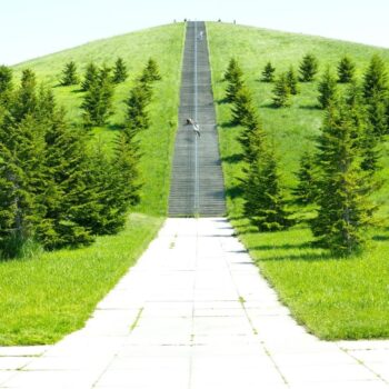 Path through green park stretching upwards