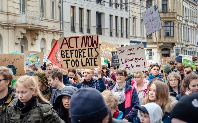 People asking for climate action in a demonstration with placards in English and German, where it can be read 