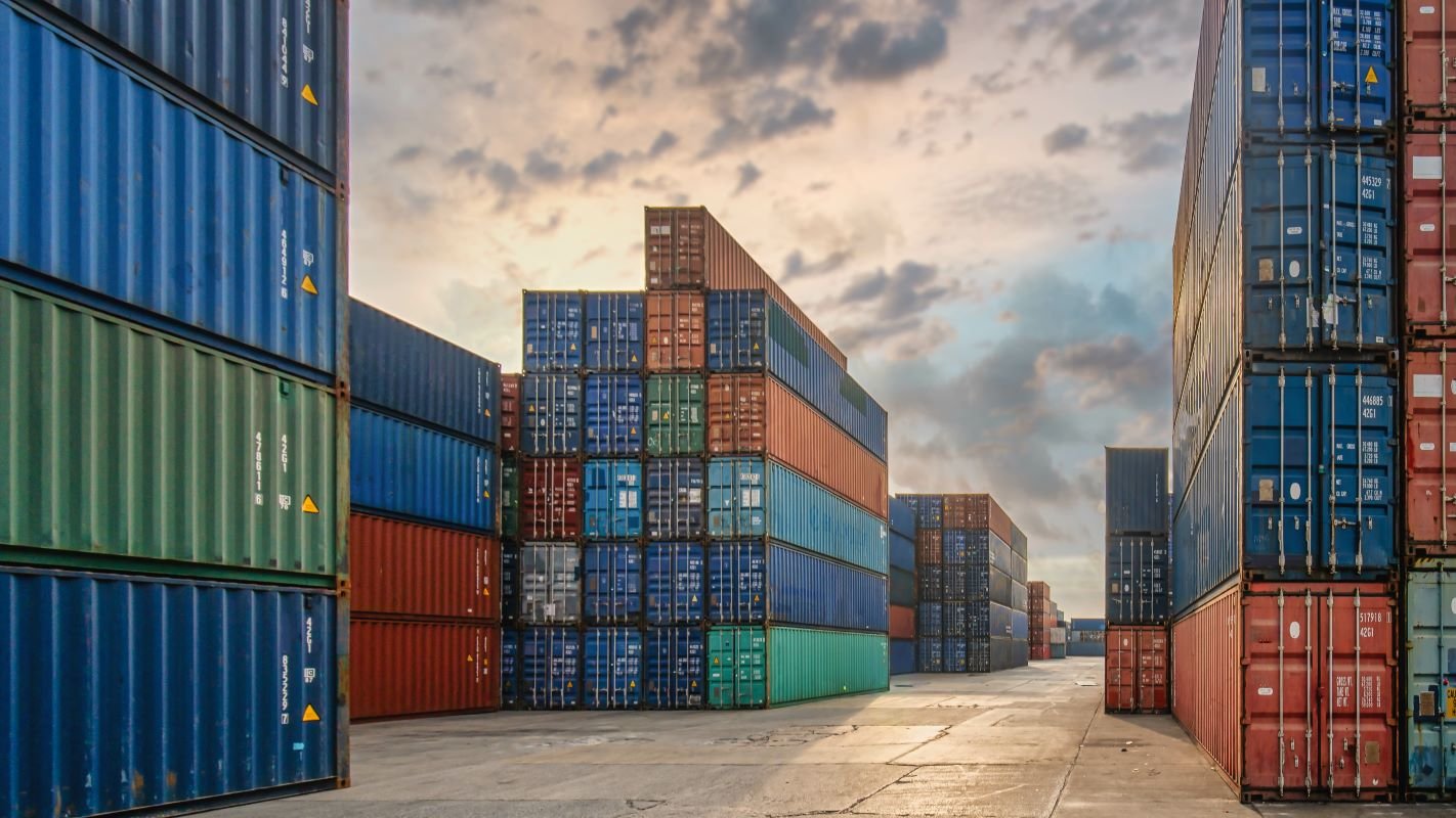 Perspective view of containers at containers yard with forklift and . Photo via Adobe