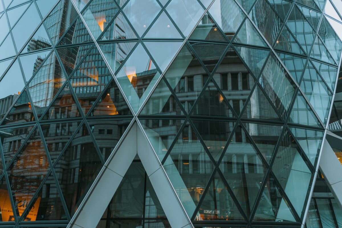 Reflection of the finance district of London in the Gherkin. Photo by Constantin Hyp on Unsplash.
