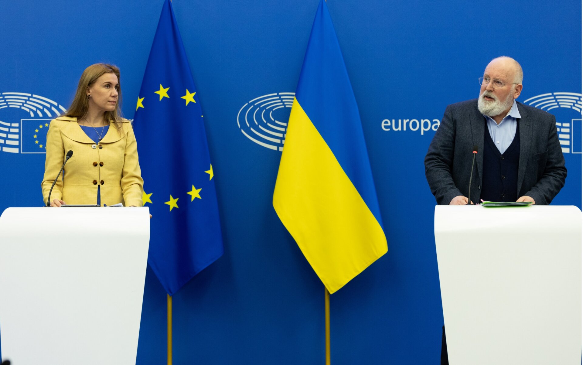 This is an image of the presentation of the RePowerEU Communication by Kadri Simson, European Commissioner for Energy, and Frans Timmermans, Executive Vice-President of the European Commission in charge of the European Green Deal, with flags of the European Union and Ukraine in the background.