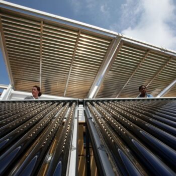 Two engineers look out over FIU Solar Thermal Collector System. Photo by Stefano Paltera via U.S. Department of Energy Solar Decathlon on flickr.