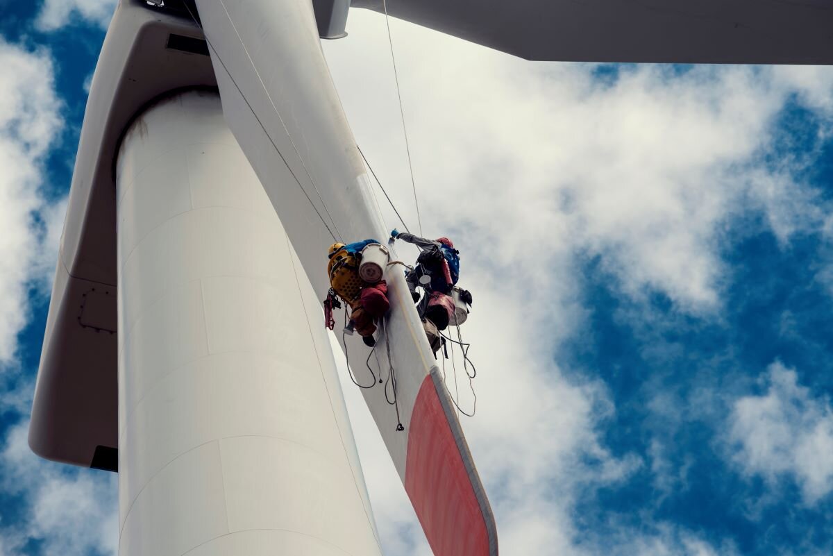 Two workers on a wind turbine in Kaliakra, Bulgaria, September 2020. Power systems must change on the path to net zero. Photo via Adobe.