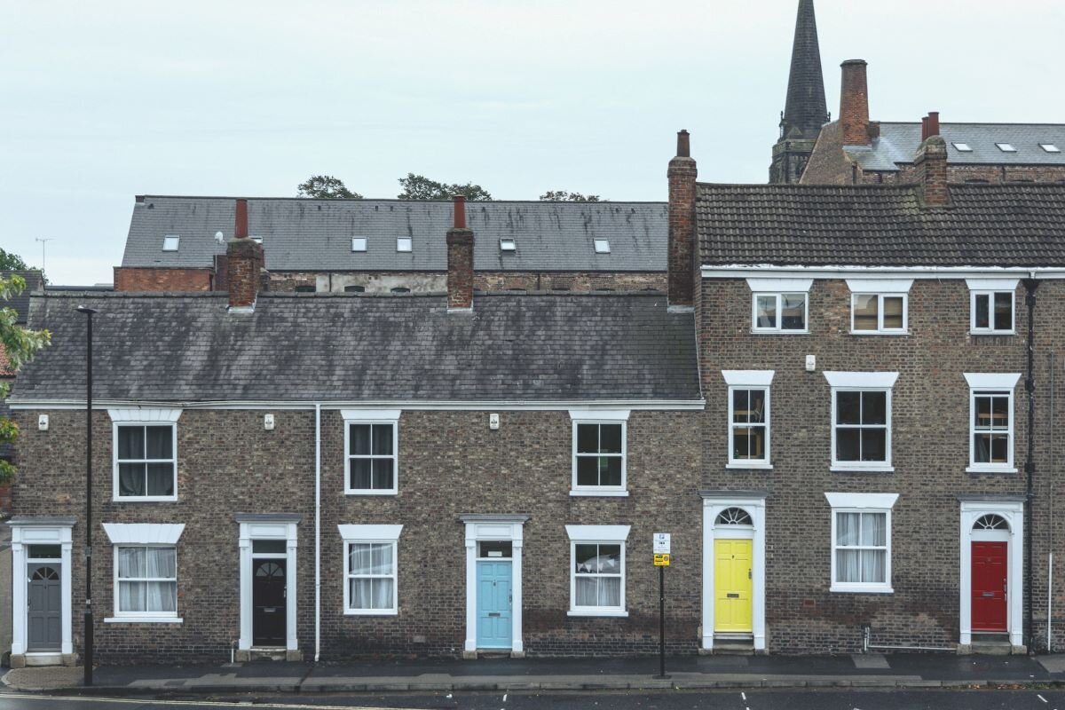 A row of houses with brightly coloured front doors.