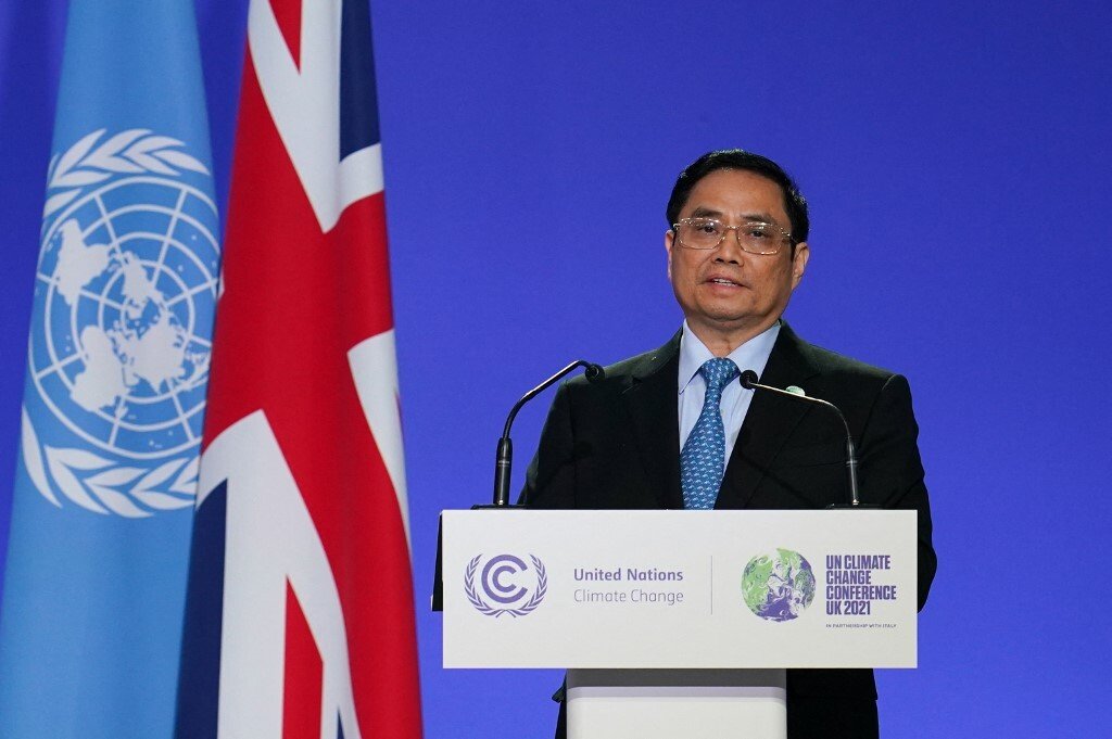 Vietnam's Prime Minister Pham Minh Chinh, who committed the country to no new coal at COP26, presents his national statement as part of the COP World Leaders' Summit in Glasgow. Behind him are UN and UK flags.