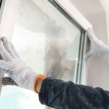 Worker installing new windows for better home insulation. Photo via Adobe.